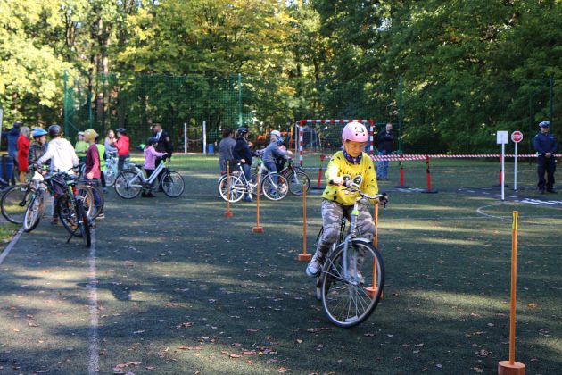 Egzamin na kartę rowerową w Zalesiu Górnym. Na zdjęciu uczeń przystępuje do egzaminu. W tle inni uczestnicy egzaminu.