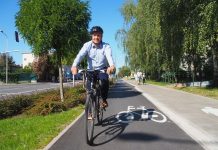 Na zdjęciu Daniel Putkiewicz Burmistrz Miasta i Gminy Piaseczno jadący rowerem po ścieżce rowerowej przy ul. Powstańców Warszawy w Piasecznie, na głowie ma kask.