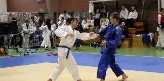 Ikizama Judo CUP III - WOM, Piaseczno. Na zdjęciu dwóch walczących na macie zawodników, w tle inni zawodnicy.