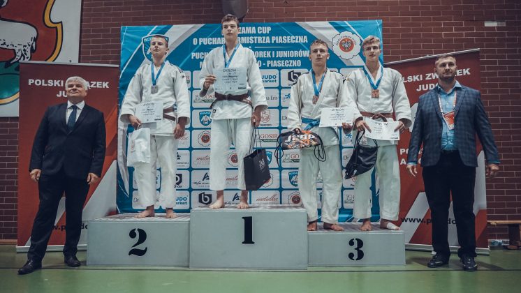 Na zdjęciu czterech zawodników stojących na podium po dekoracji medalowej.