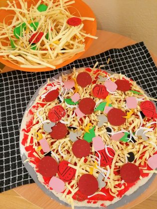 Zdjęcie. Kulinarne Podróże po Świecie w Nefrytowym Zakątku. Na zdjęciu wykonane prace plastyczne przez dzieci przedstawiające pizzę i talerz z makaronem.