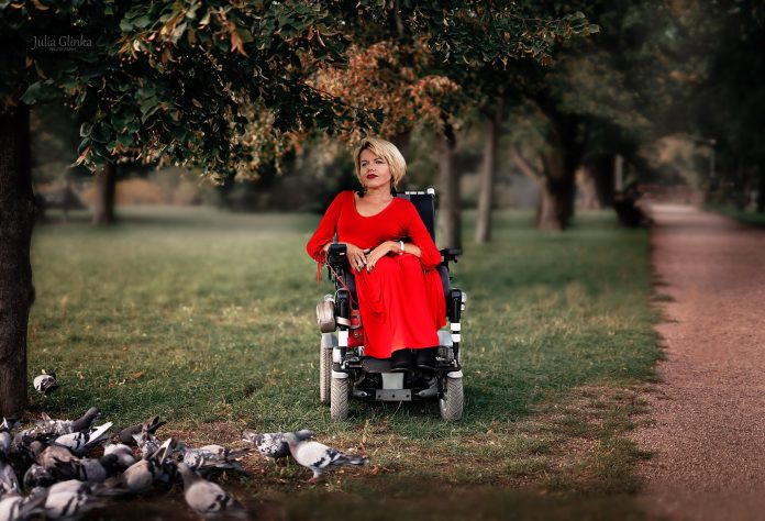 Na zdjęciu Edyta Banasiewicz siedząca na wózku w parku miejskim w Piasecznie