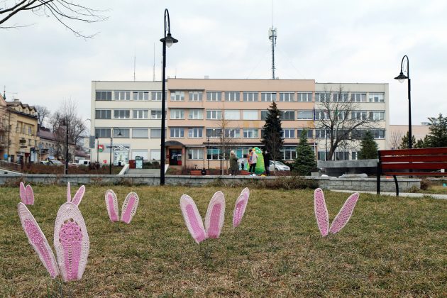 Ilustracja. Wielkanocne ozdoby na skwerze Kisiela w Piasecznie, w tle budynek Urzędu Miasta i Gminy Piaseczno