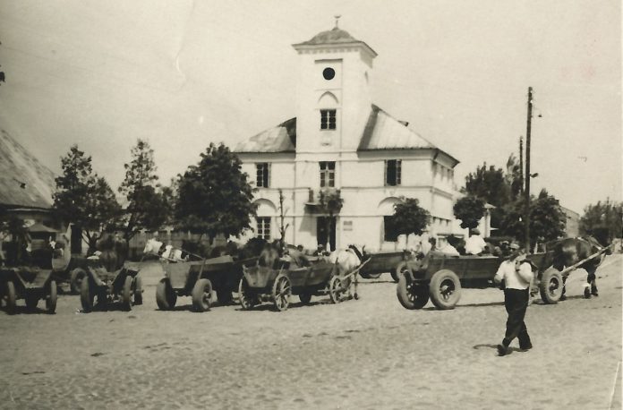 Ilustracja. Historyczna terenowa gra miejska w Piasecznie. Na zdjęciu historyczny rynek przy Ratuszu w Piasecznie.