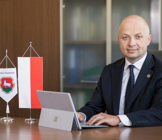 Daniel Putkiewicz Burmistrz Miasta i Gminy Piaseczno z laptopem w gabinecie UMiG Piaseczno