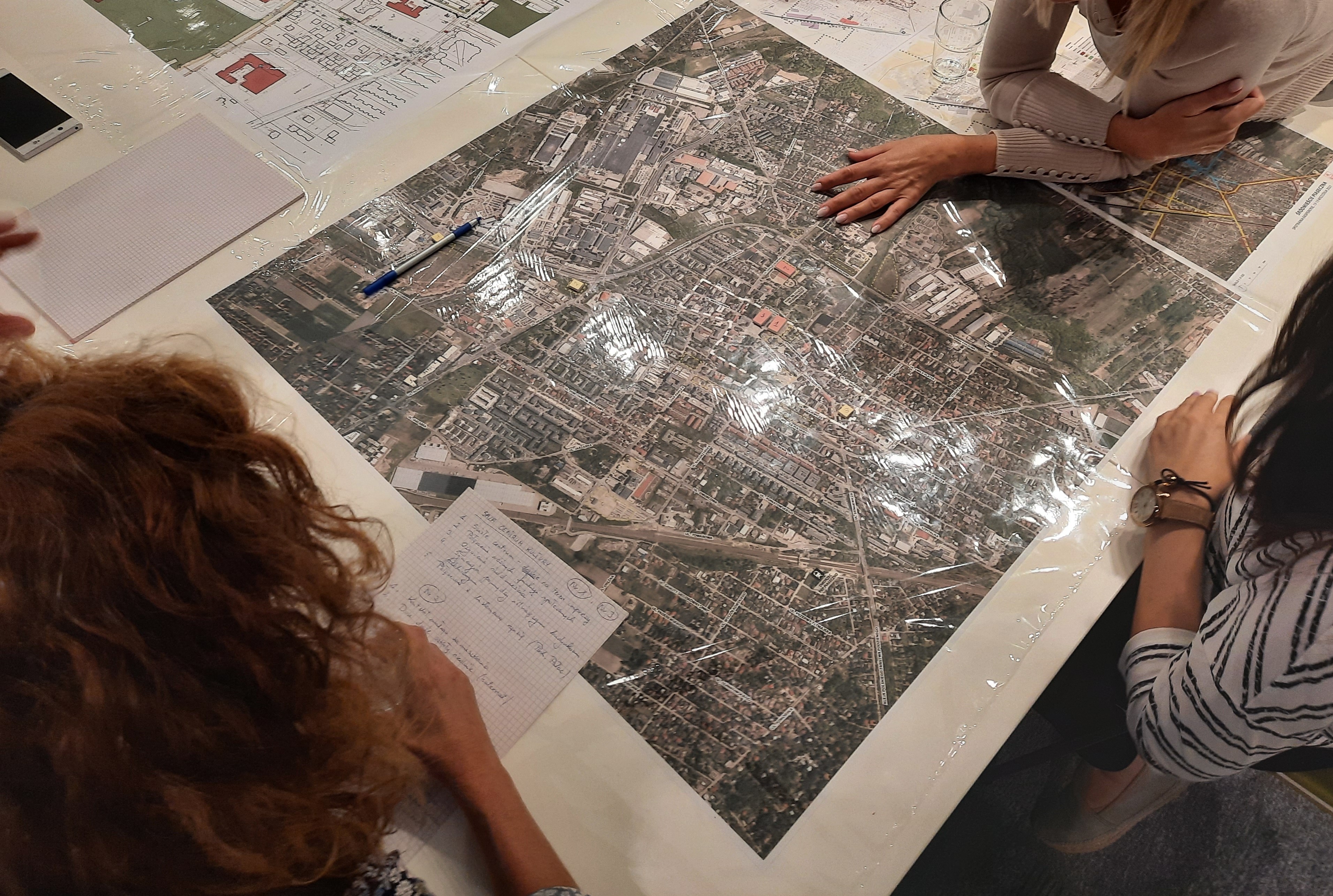 Jakie centrum Piaseczna? Na zdjęciu urzędnicy i rozłożona na stole mapa miasta.