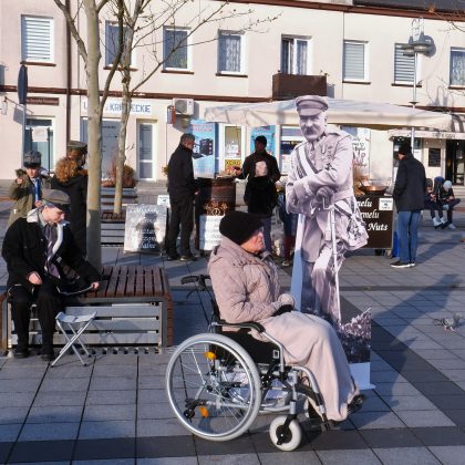 Dzień Niepodległości 2021 w Piasecznie. Na zdjęciu kobieta na wózku inwalidzkim obok makiety z Józefem Piłsudskim.