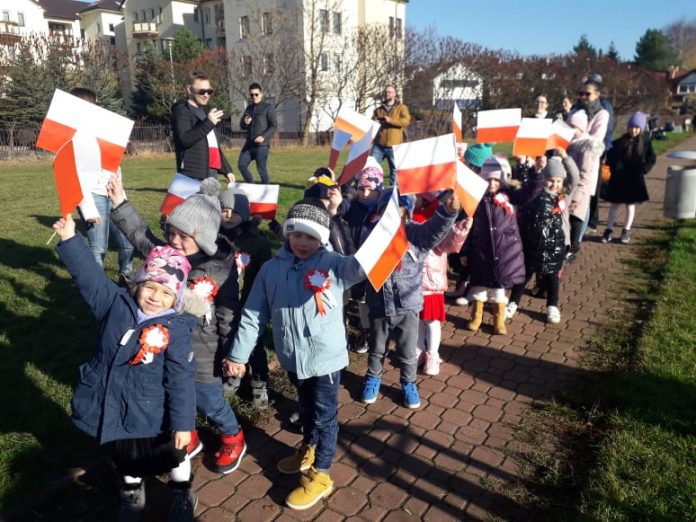 Najmłodsi świętowali Dzień Niepodległości. na zdjęciu dzieci maszerują z flagami.