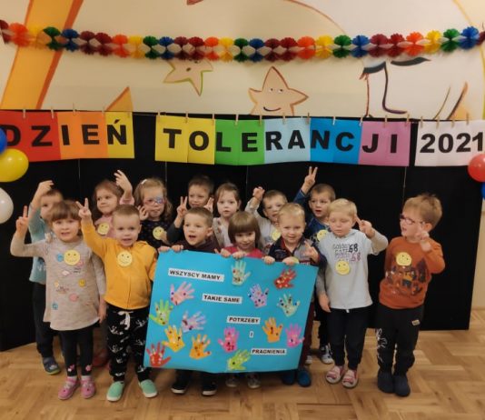 Przedszkolaki uczyły się tolerancji. Na zdjęciu grupa przedszkolaków z plakatem, pod napisem: Dzień Tolerancji 2021.