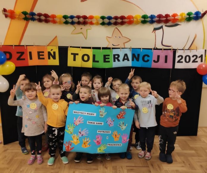 Przedszkolaki uczyły się tolerancji. Na zdjęciu grupa przedszkolaków z plakatem, pod napisem: Dzień Tolerancji 2021.