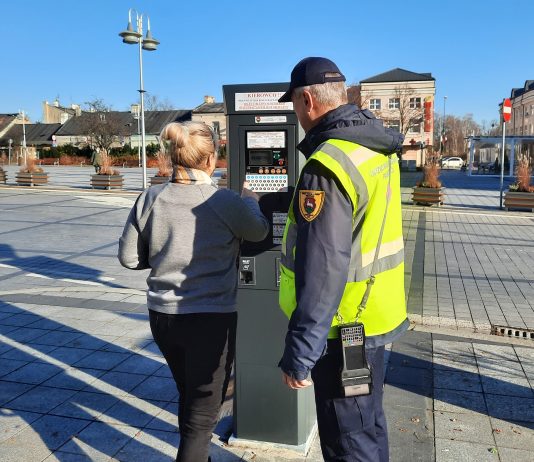 Obrażanie kontrolerów czy strażników miejskich może sporo kosztować. na zdjęciu kontroler pomagający kobiecie kupić bilet parkingowy w parkomacie przy pl. Piłsudskiego.