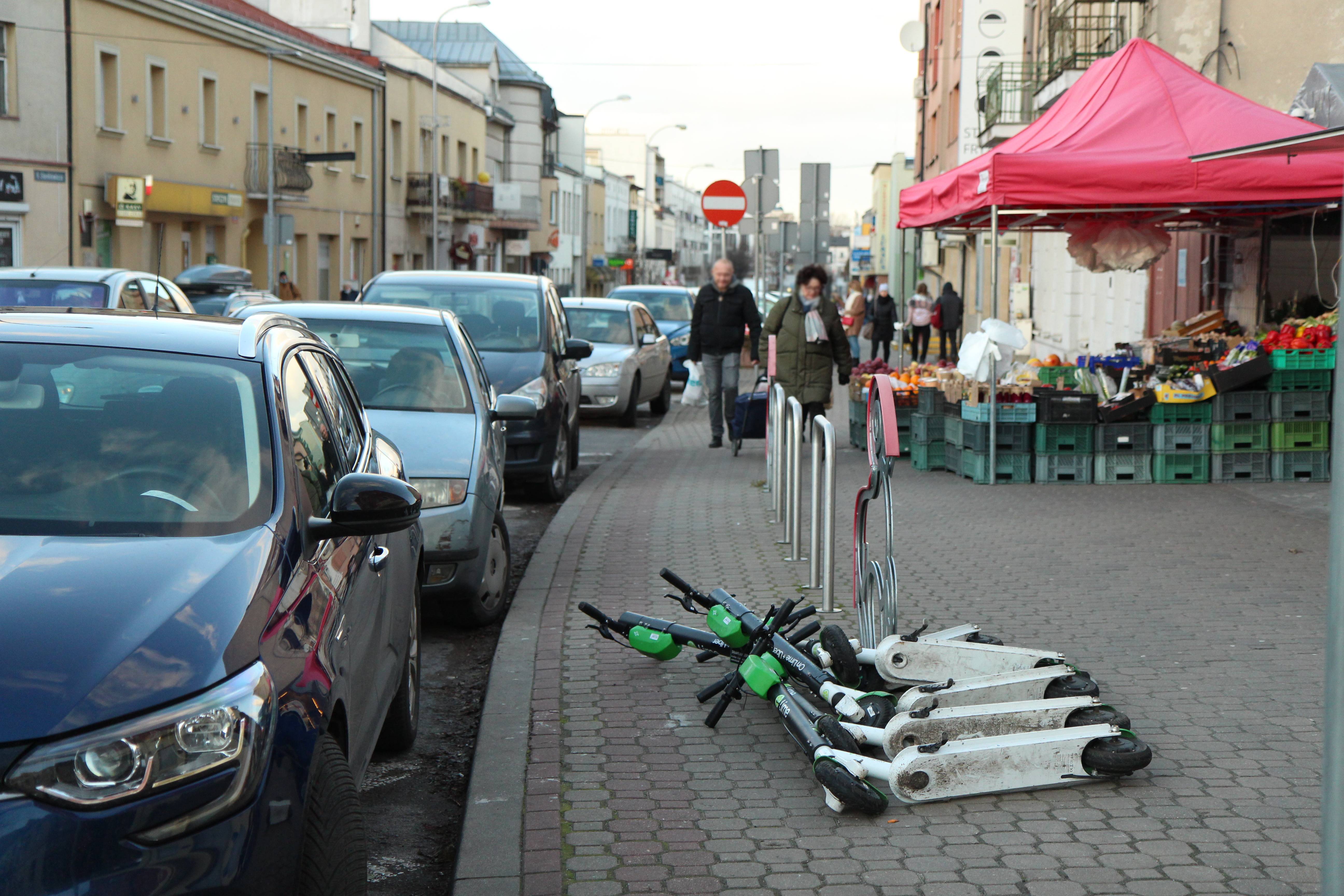 Patrzymy w przyszłość – zmieniamy centrum miasta. Na zdjęciu ulica Kościuszki z rozłożonym straganem, przewróconymi hulajnogami i zaparkowanymi samochodami.