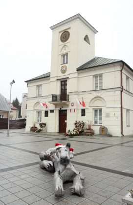 Mikołajkowe czapeczki od "Zamotanych w Piasecznie" ozdobiły miasto. Na zdjęciu rzeźba lwicy i lwiątka w czapeczkach, w tle Ratusz.