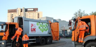PUK Piaseczno ogranicza współpracę z przedsiębiorcami. Na zdjęciu 2 śmieciarki oraz pracownicy PUK Piaseczno