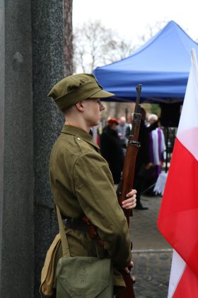 młody człowiek z flaga polski w stroju żołnierza