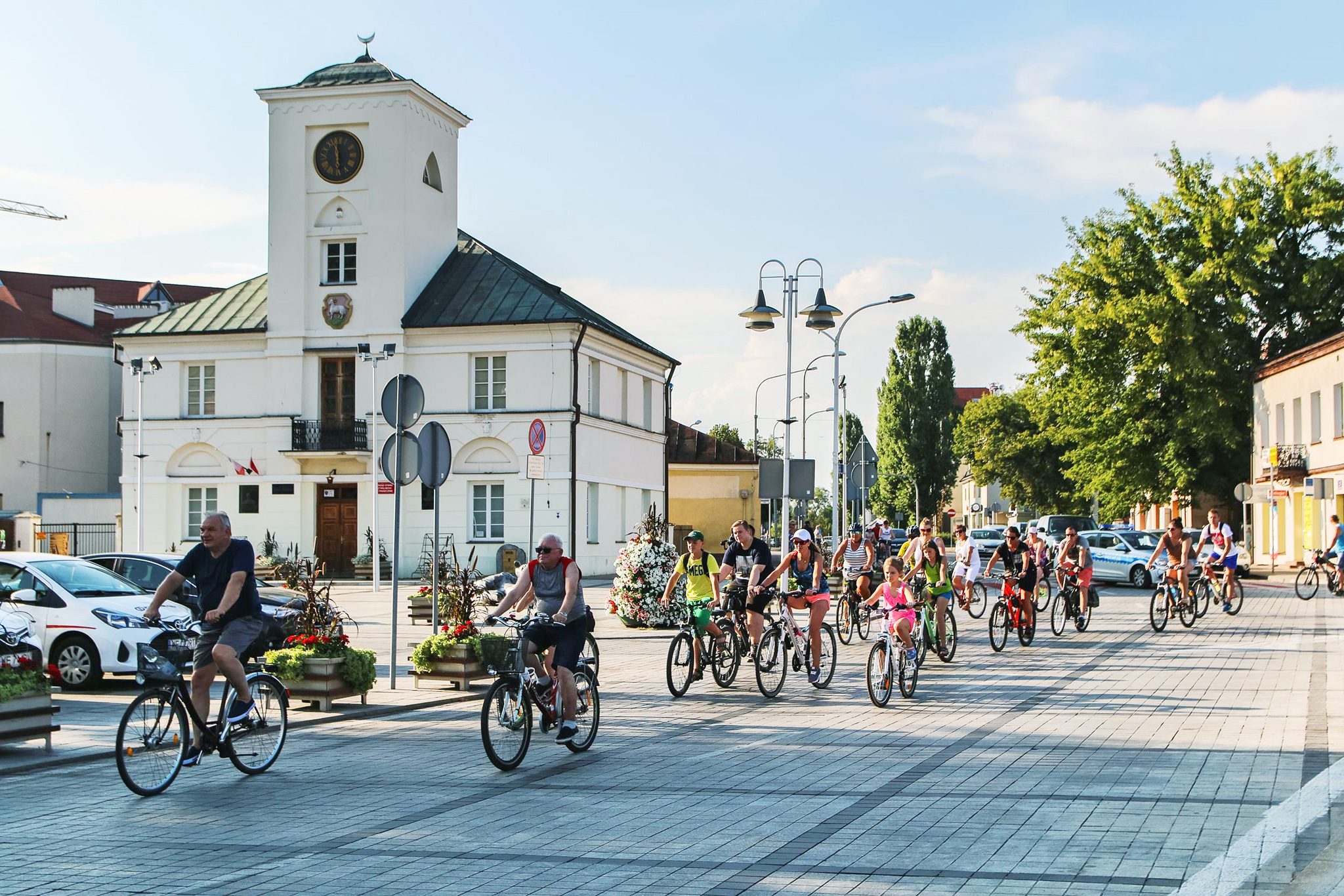 Rowerowe Piaseczno, na zdjęciu rowerzyści, w tle Ratusz w Piasecznie
