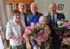 100-latka z Żabieńca. na zdjęciu Jubilatka z kwiatami, Burmistrz i inni goście