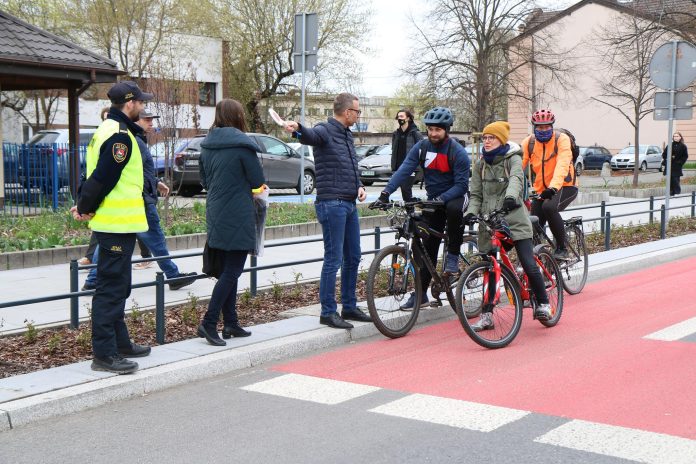 Rowerowe Piaseczno - akcja edukacyjna na ścieżkach rowerowych. na zdjęciu pas rowerowy na ul. Puławskiej, burmistrz, strażnik miejski i rowerzyści.