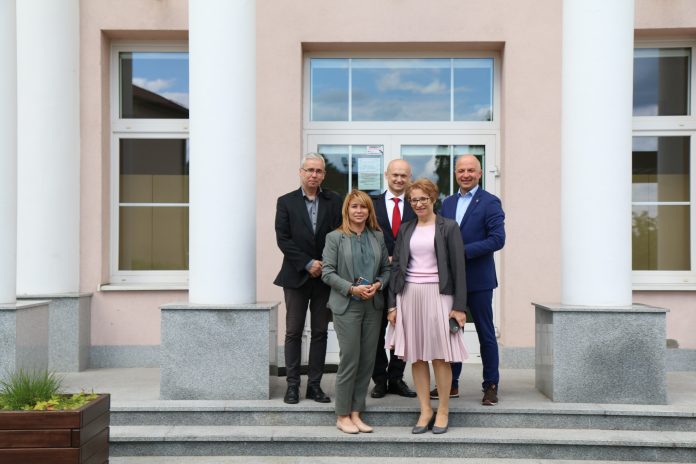Przedstawiciel Komisji Europejskiej w Piasecznie wspólne zdjęcie gości i gospodarzy (przedstawiciel KE oraz przedstawiciele gminy) przed wejsciem do szkoły