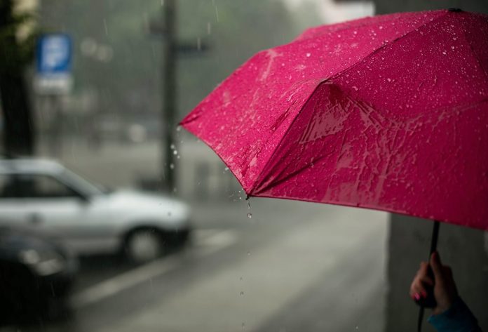 Ostrzeżenie przezd deszczem. Na zdjęciu różowa parasolka.