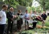 groby powstańców w Piasecznie. Burmistrz Daniel Putkiewicz oraz 5 innych osób ze zniczami i kwiatami na cmentarzu.