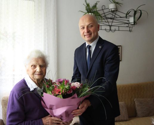 100 -latka z Burmistrzem i bukietem fioletowych kwiatów