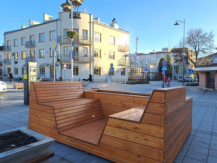 Parklet. Na zdjęciu drewniana ławka z donicą.