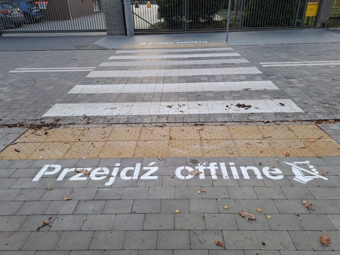 przejdź offline. na zdjęciu wymalowany napis przed przejściem dla pieszych.