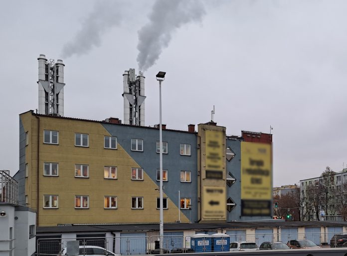 PCU Piaseczno. Na zdjęciu budynek ciepłowni z komi8nami i lecącym z nich dymem.