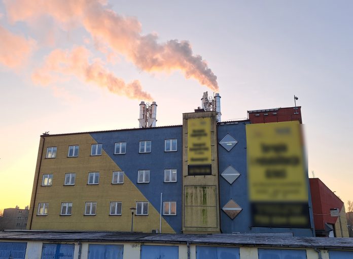 PCU. Na zdjęciu budynek ciepłowni, z kominów leci dym.