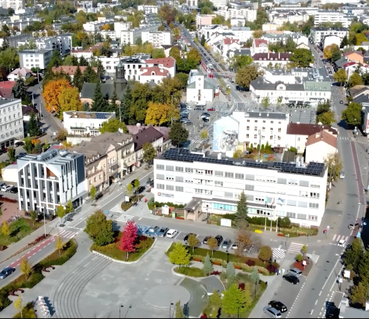 Widok na Piaseczno z drona, na zdjęciu m.in. budynek urzędu, sądu, policji, kościół św. Anny, ratusza i innych budynków w centrum Piaseczna
