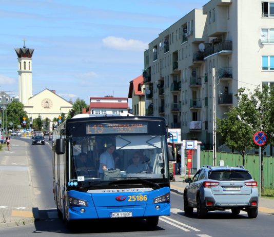 Autobus linii L13. na zdjęciu niebieski autobus, w tle kościół.