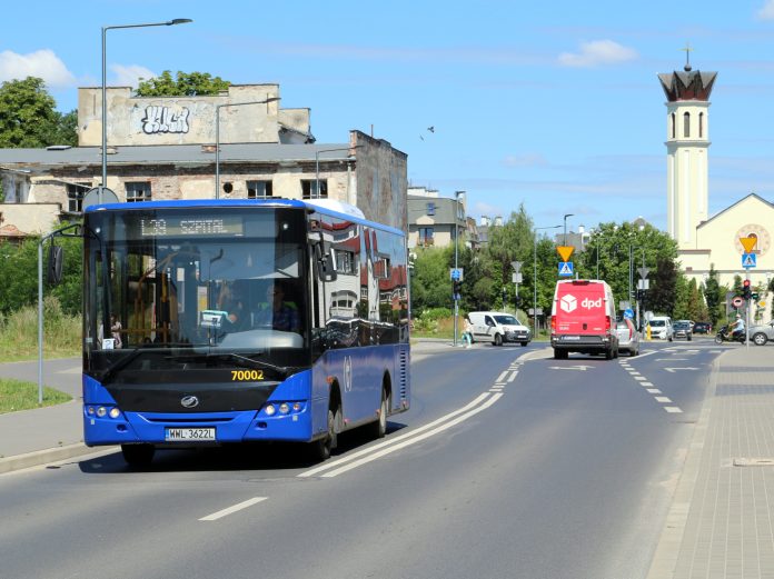 autobus L39. Na zdjęciu niebieski autobus, w tle kościół i inne samochody.