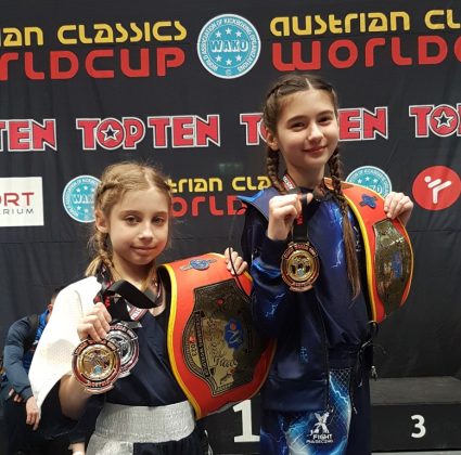 dziewczynki w sportowych strojach ze zdobytymi medalami w dłoniach