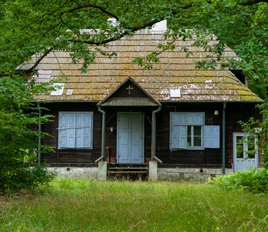 Dom Zośki. na zdjęciu drewniany dom w otoczeniu zieleni.