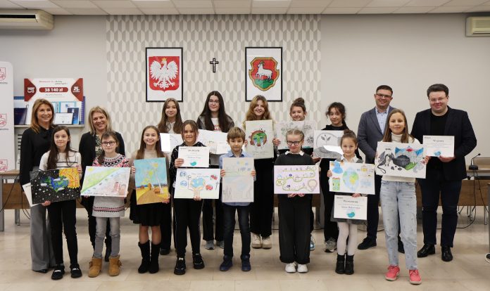 grupowe zdjęcie laureatów z pracami plastycznymi