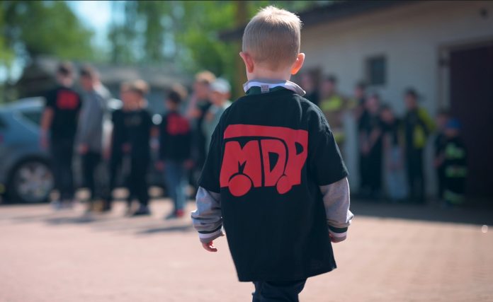 Dołącz do Młodzieżowej Drużyny Pożarniczej MDP. Dziecko w koszulce z napisem MDP