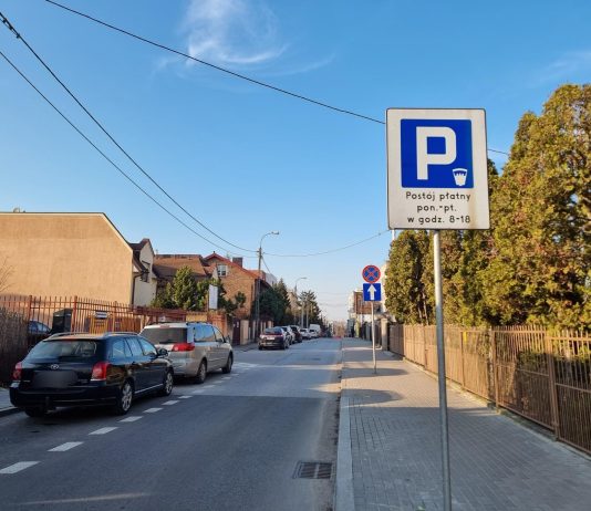 zdjecie ulicy z samochodami i znakiem "parking"