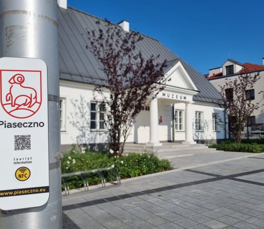 kod qr na słupie, w tle muzeum