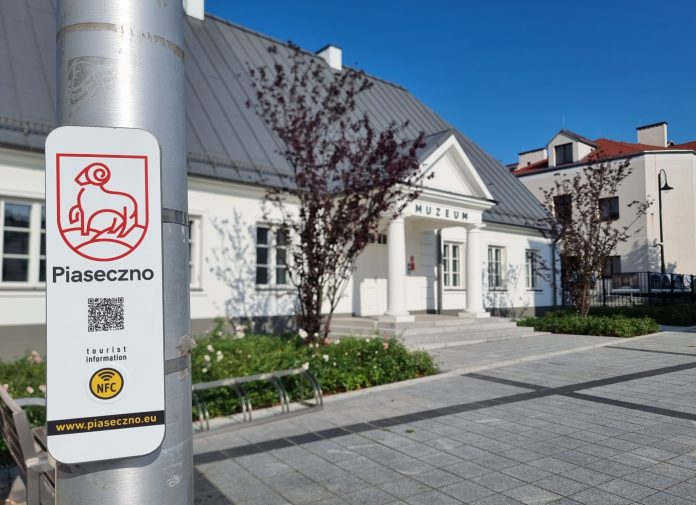 kod qr na słupie, w tle muzeum