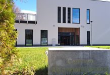 Symboliczny gest Przystani pod Klonami przeciw przemocy wobec do dzieci biały budynek, w pierwszym planie kamień z napisem: Centrum Aktywności Seniora