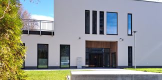 biały budynek, w pierwszym planie kamień z napisem: Centrum Aktywności Seniora