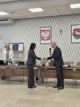 powitanie, wręczenie kwiat&oacute;w, dyrektor przy mikrofonie