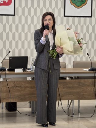 powitanie, wręczenie kwiat&oacute;w, dyrektor przy mikrofonie