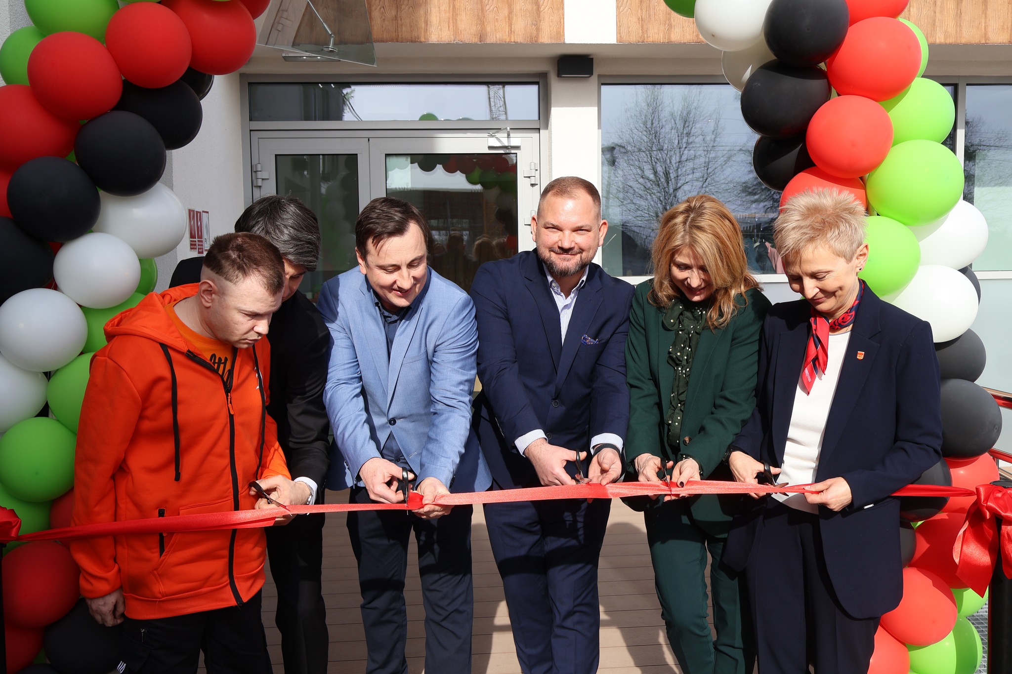 kilka osób przecina wstęgę