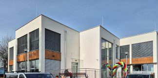 budynek i dwa samochody typu van