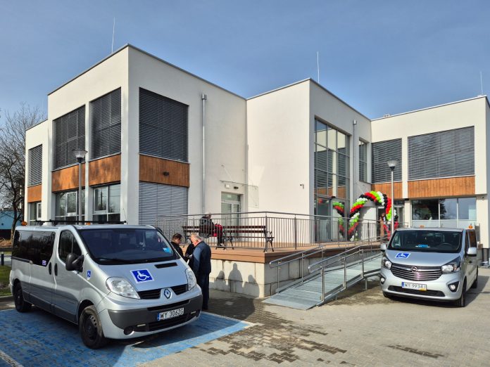 budynek i dwa samochody typu van