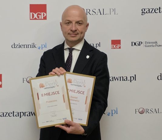 mężczyzna trzyma dwa dyplomy
