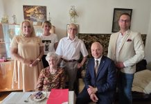 Burmistrz z urodzinową wizytą u stulatki grupa osób